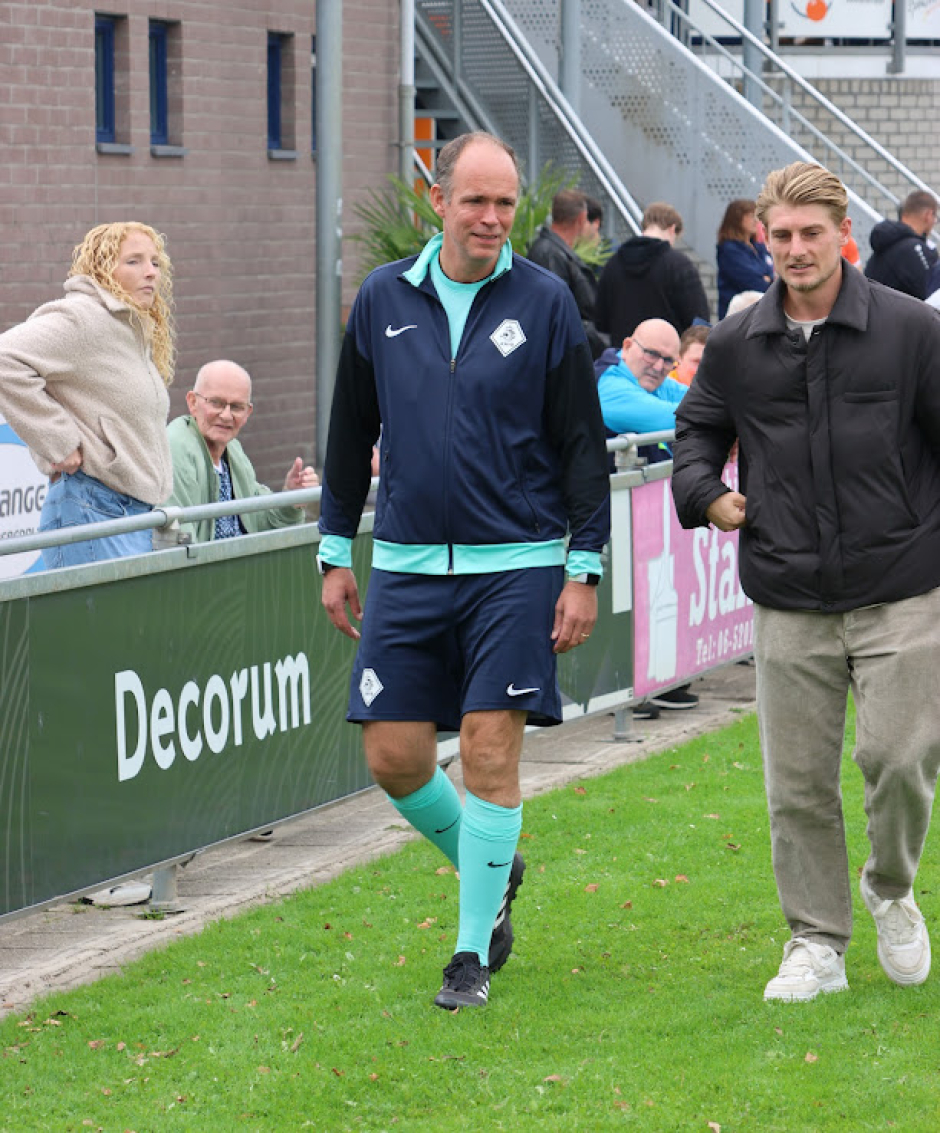 Assistent-scheidsrechter was deze wedstrijd Daan van Velzen, die onze vaste assistent Andr&eacute;s Castro waardig vervangt. Hier begeleidt Phil Altimari (r.) hem naar het veld.