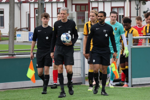 Het arbitrale trio van de middag met in het midden arbiter Leon Welbers en zijn assistenten Joran Mostert (l.) en Djayankoemar Dhoen (r.), nog onwetend van de historische wedstrijd die hen te wachten staat.
