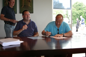 Aad Buitendijk (rechts) tekent onder kritisch toeziend oog van penningmeester Roeland Engelen en links vice-voorzitter Tonie Boven